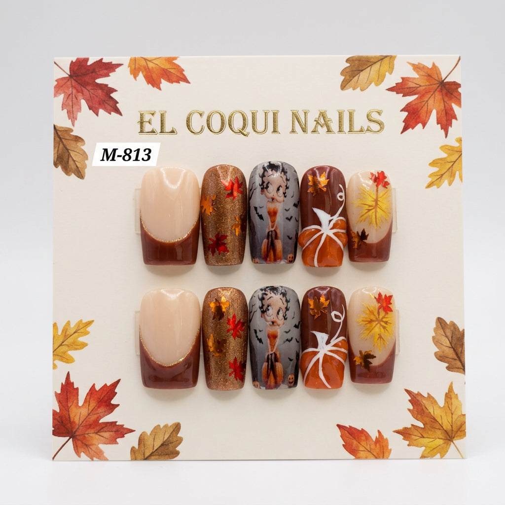 A set of 10 press-on nails in a clear plastic clamshell case by El Coqui Nails, featuring a fall/winter theme with beige, brown, gold glitter, and autumn leaf designs.