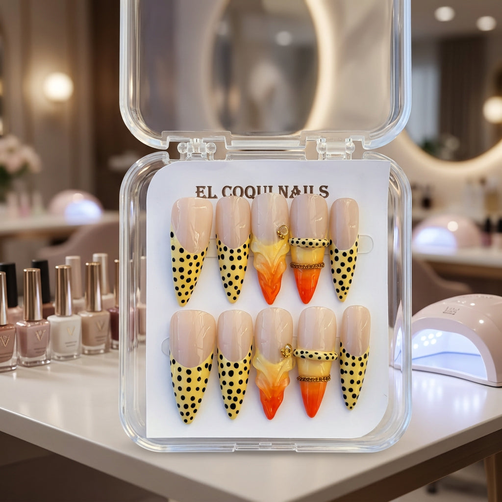 A set of 10 press-on nails in a clear plastic case, featuring a nude-pink base with black leopard spots on the lower half and orange gradient accents on some nails. The brand 'EL COQUINAILS' is visible on the packaging and a sticker.
