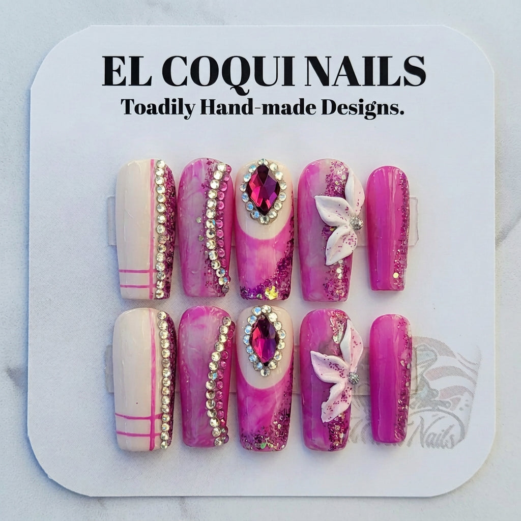 A set of 10 false press-on nails displayed on a white backing card, featuring pink and white marbled designs with rhinestone trim, glitter, and white butterfly embellishments. The brand 'EL COQUINAILS' is visible on the packaging and a logo in the top left corner.