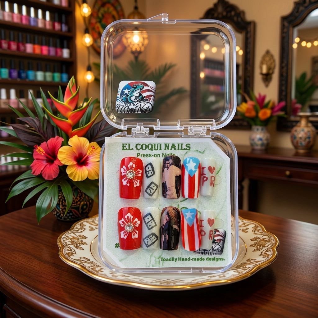 A clear plastic clamshell case containing press-on nails with patriotic designs, including red and white flowers, black and white dice, Puerto Rican flag motifs, and a frog design. The packaging card reads 'EL COQUI NAILS'.
