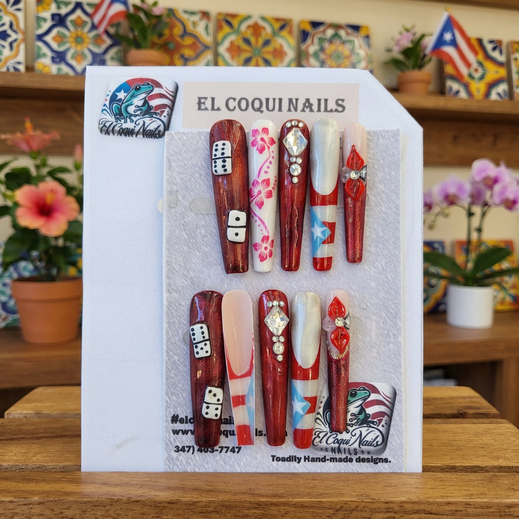 A set of 10 press-on nails displayed on a card, featuring patriotic red, white, and blue designs with stars, stripes, dice, and floral patterns. The brand 'El Coquinails' is visible on the packaging and sticker.